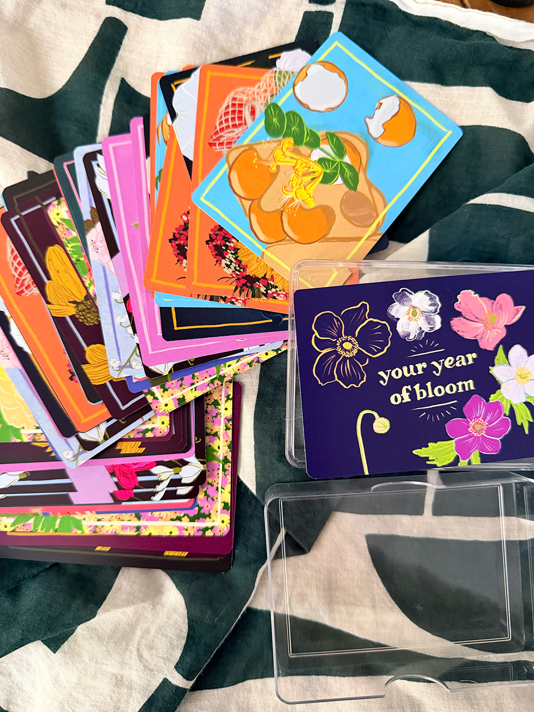 Your Year of Bloom manifestation card deck — 52 weekly intention cards with botanical illustration, clear carrying case.